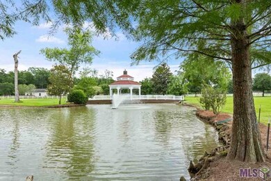Lake features two fountains and a gazebo with a br