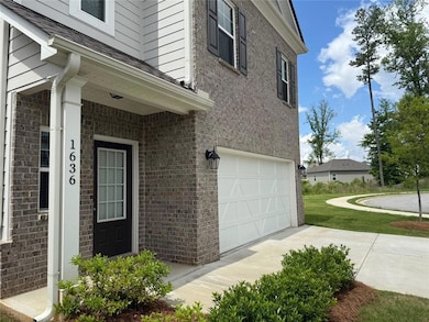 Property entrance with a garage, concrete driveway