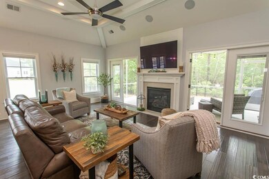 Living area featuring a tiled fireplace, ceiling f