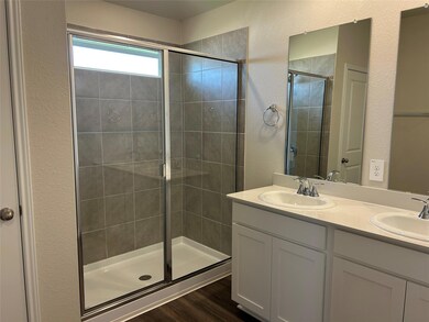 Bathroom with a stall shower, double vanity, a te