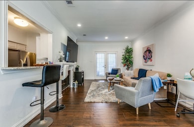 Living room with crown molding, dark wood finished floors, french doors, a fireplace, and recessed lighting
