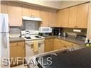 Kitchen with freestanding refrigerator and ventila