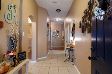 Corridor featuring light tile patterned floors and arched walkways