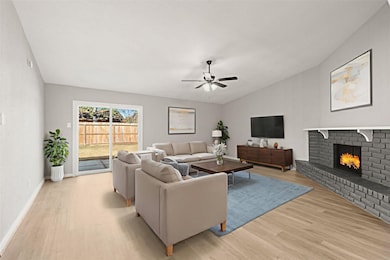 EXPANSIVE LIVING ROOM FEATURING A PAINTED BRICK FIREPLACE WITH A WHITE MANTEL. THE GLASS SLIDING DOOR PROVIDES ACCESS TO THE BACKAYRD. *Virtually Staged