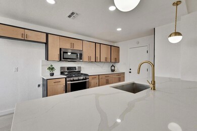 Kitchen with visible vents, light stone counterto