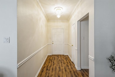 Corridor with baseboards, dark wood-type flooring,