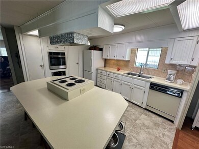 Kitchen with white cabinets, tasteful backsplash, 