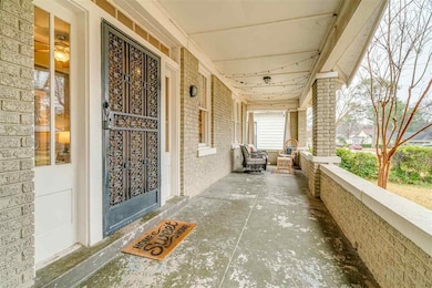 Property entrance with covered porch and brick siding