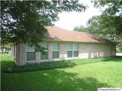 Side view, neatly landscaped yard. Sunroom view.