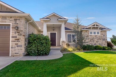 Entrance to property with stone siding, a lawn, and covered porch