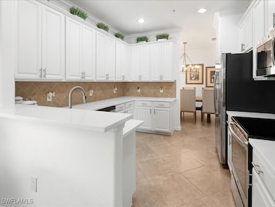 Kitchen with white cabinetry, decorative backsplash, hanging light fixtures, a peninsula, and light tile patterned flooring