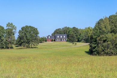 View of grassy front yard with a view of countryside and a forest view