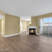 Unfurnished living room featuring baseboards, wood