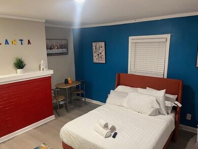 Bedroom featuring wood finished floors, baseboards, and crown molding