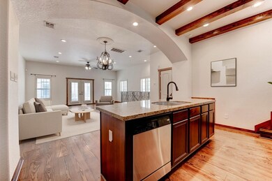 Warm wood cabinetry, arched details, and generous counter space make this kitchen as functional as it is beautiful.