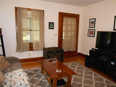 The living room has hardwood floors, original wind