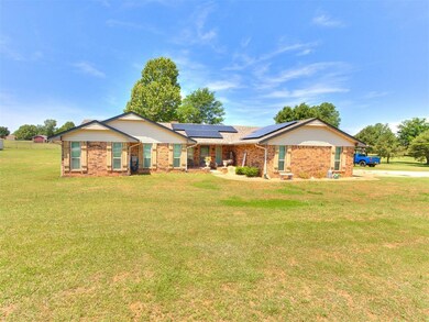 Single story home with solar panels, a front yard, and brick siding