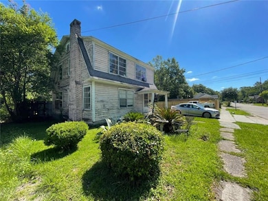 View of property exterior with a chimney and a yard