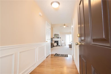 Hall with light wood-style floors and wainscoting