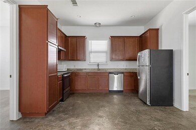 Kitchen with a sink, stone countertops, concrete 