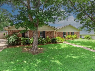 Single story home with brick siding and a front yard