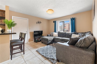 Living room with baseboards, a textured ceiling, a
