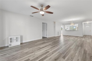 Unfurnished living room with a ceiling fan, light wood-style flooring, and baseboards