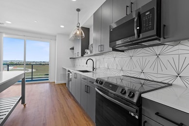 Kitchen with range with electric stovetop, light wood-style floors, decorative backsplash, open shelves, and recessed lighting