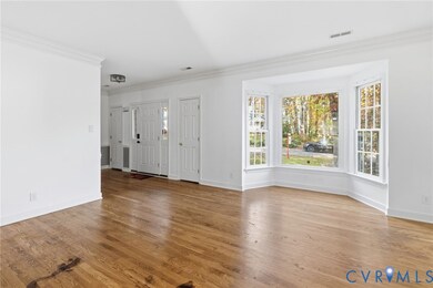 Unfurnished living room with ornamental molding and light wood-type flooring