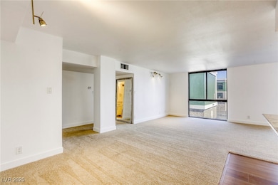 Unfurnished living room featuring carpet floors, b