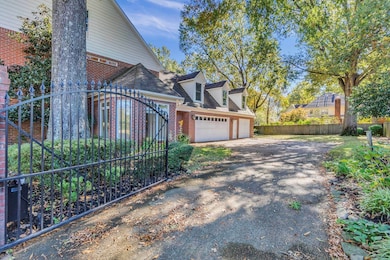 View of property exterior with roof with shingles, asphalt driveway, brick siding, and a garage