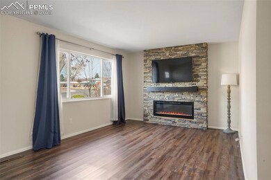 Unfurnished living room featuring baseboards, a fi