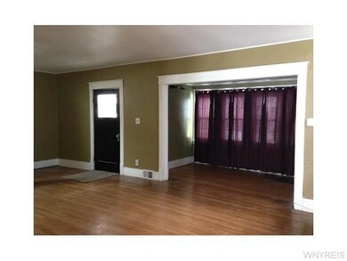 Living Room Entrance door to separate foyer and additional from room with a wall of windows