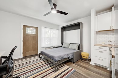 Bedroom with baseboards, light wood-style floors,