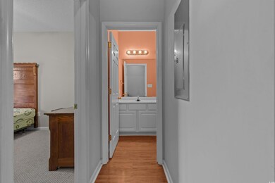 Hall with a sink, light wood finished floors, and baseboards