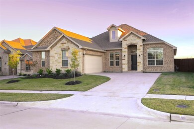 View of front facade featuring a garage and a lawn