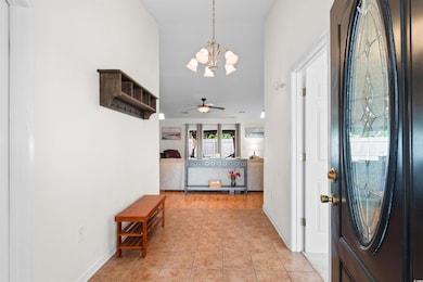 Foyer entrance featuring a chandelier, ceiling fan