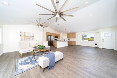 Living space with large ceiling fans and abundant lighting.