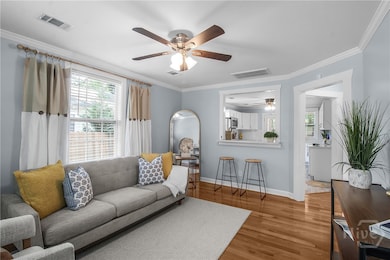 Quaint, cozy living room seamlessly opens to the kitchen, featuring bar-level seating that connects both spaces for easy entertaining and everyday comfort.