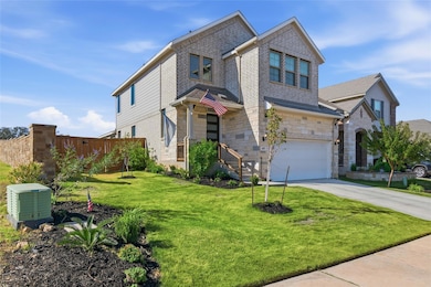 View of front of home with driveway, a garage, and stone siding
