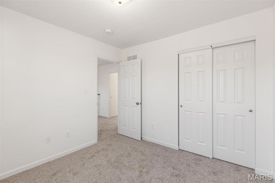 Unfurnished bedroom with light colored carpet and a closet
