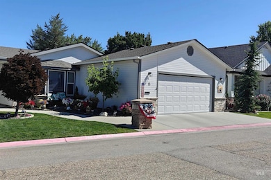 Ranch-style house with an attached garage, driveway, a front yard, and a shingled roof