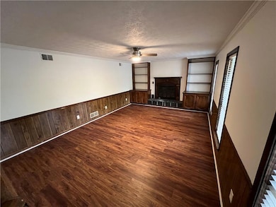 Unfurnished living room featuring ceiling fan, vis