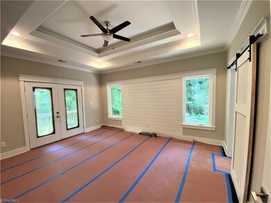 The Master Bedroom Suite is situated at the back of the house.  Note the double doors that lead to the wrap around porch.  The trey ceilings, molding, and lighting add a dramatic flare.