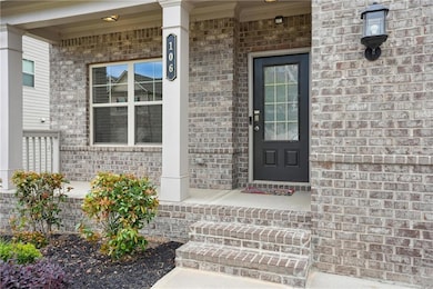 Doorway to property featuring a porch and brick siding