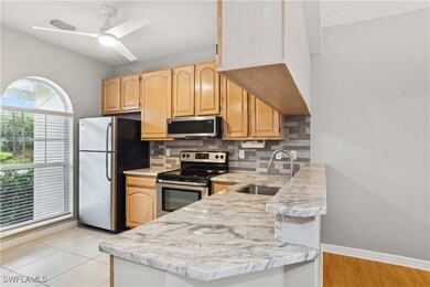 Kitchen with stainless steel appliances, sink, light brown cabinets, ceiling fan, and backsplash