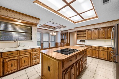 Kitchen featuring black electric stovetop, sink, p