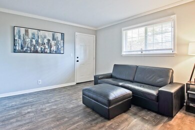 Living room with wood finished floors and ornamental molding
