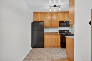 Kitchen featuring black appliances and brown cabinetry