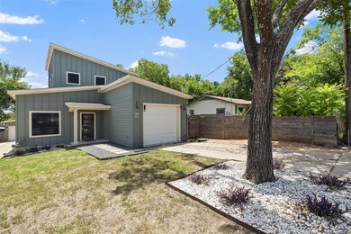 View of front facade featuring a garage, fence, a